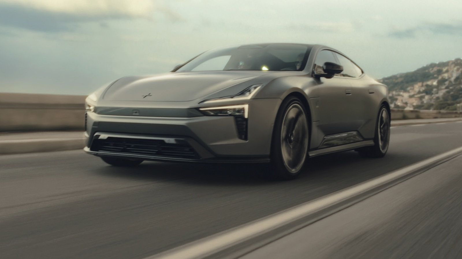 Polestar 5 electric grand tourer driving on a coastal road