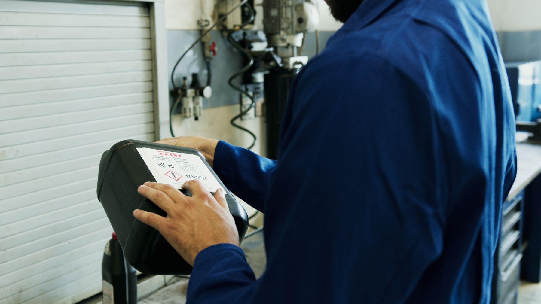 Mechanic using a diagnostic tool during a vehicle inspection in a workshop