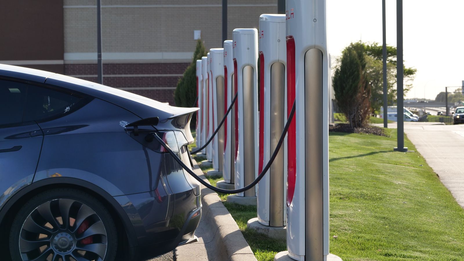 An electric car connected to a row of public charging stations