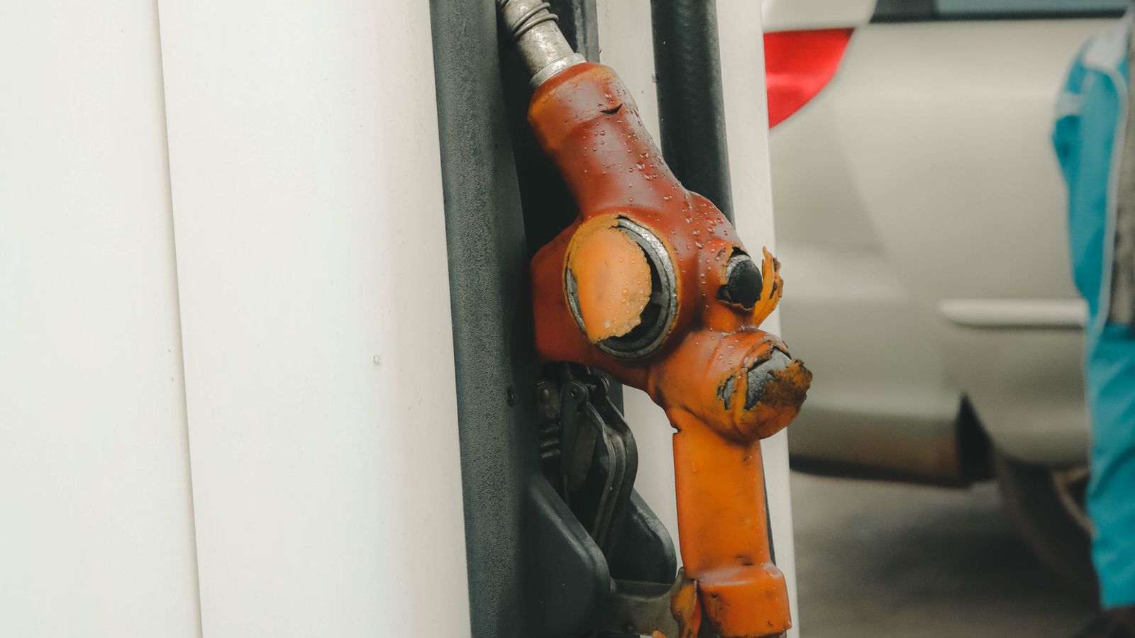 Close-up of an orange gasoline nozzle at a fuel pump