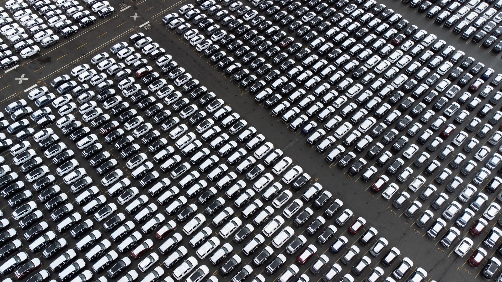 Aerial view of rows of new vehicles in a large inventory lot