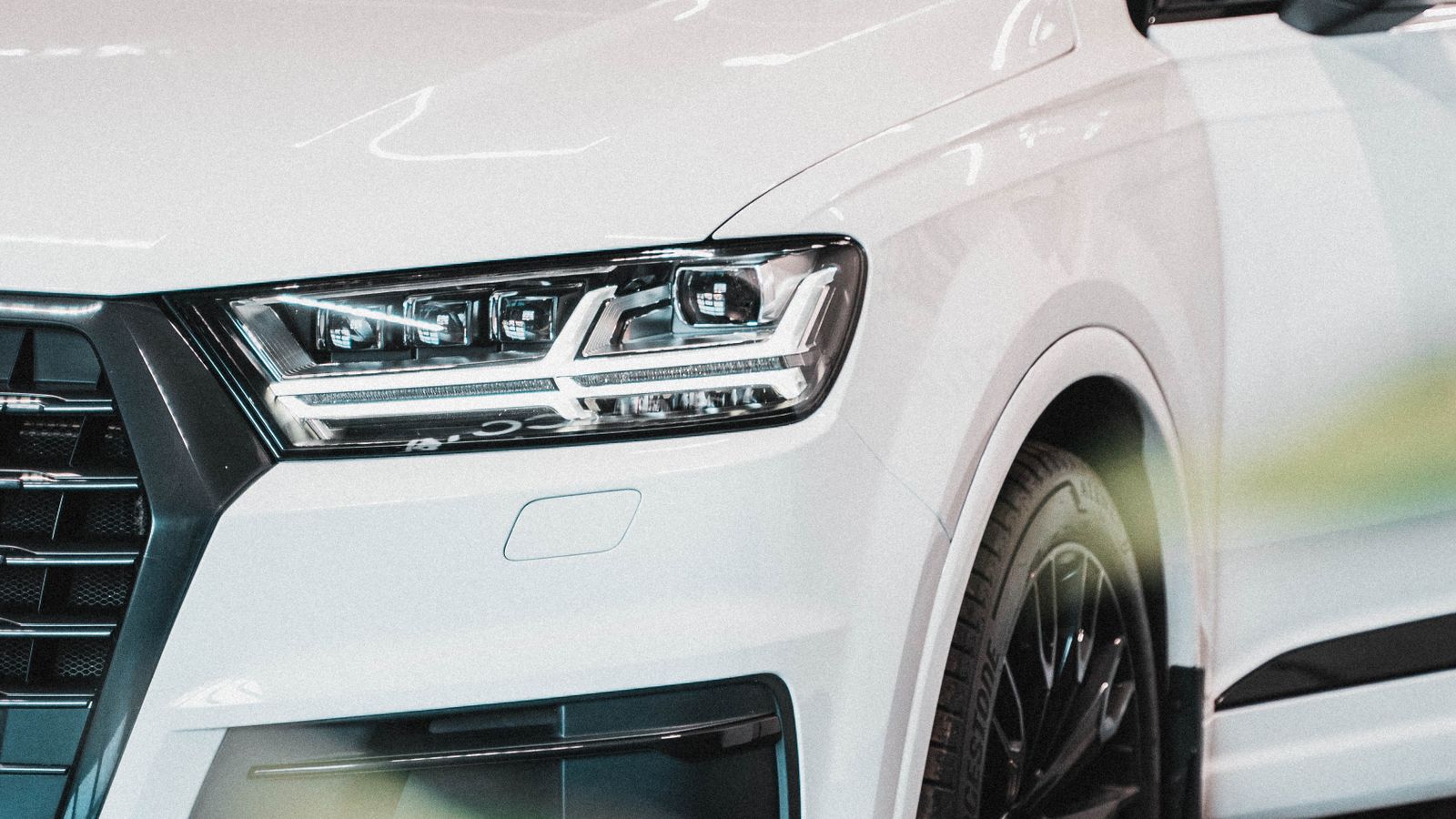 Close-up of a white SUV displayed in an indoor showroom