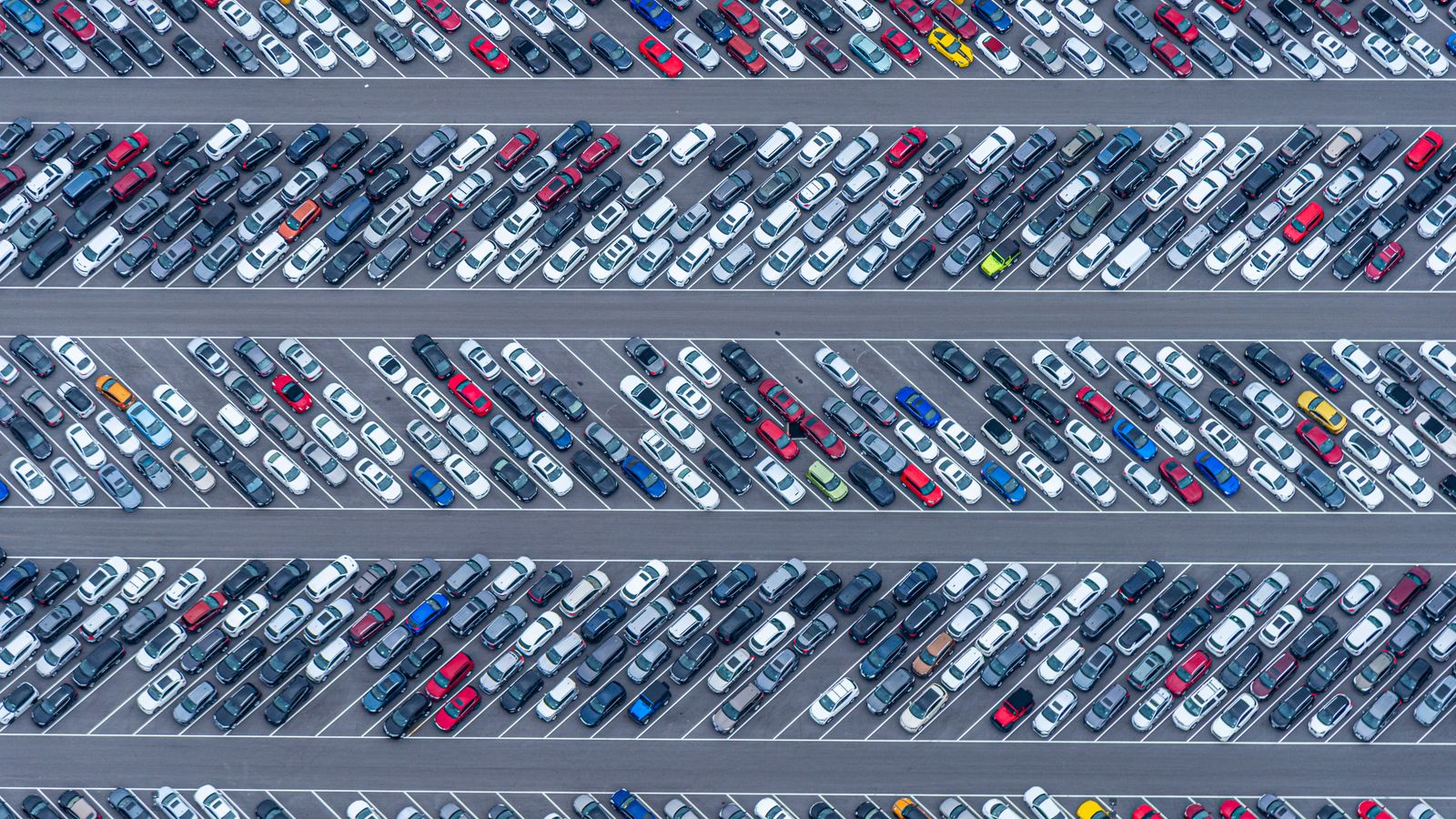Aerial view of a crowded vehicle lot with rows of cars